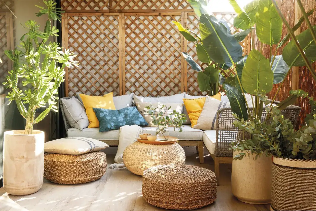 Acogedor rinc&oacute;n con sof&aacute;, cojines coloridos y plantas exuberantes. Un espacio perfecto para disfrutar de terrazas peque&ntilde;as con encanto.