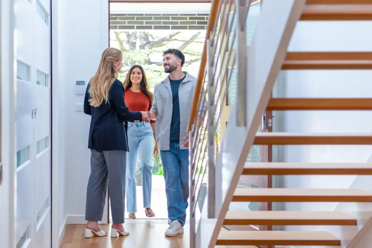 Agente inmobiliaria saluda a pareja. Tienen un contrato de alquiler y quieren vender el piso.