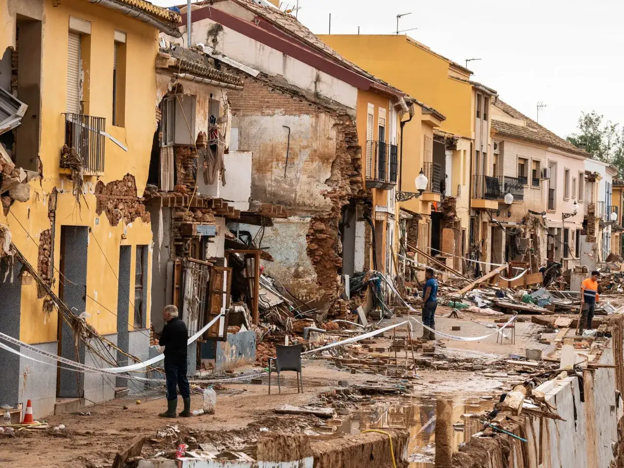 Edificios devastados por inundaciones, escombros y barro cubren la calle. La cinta de 