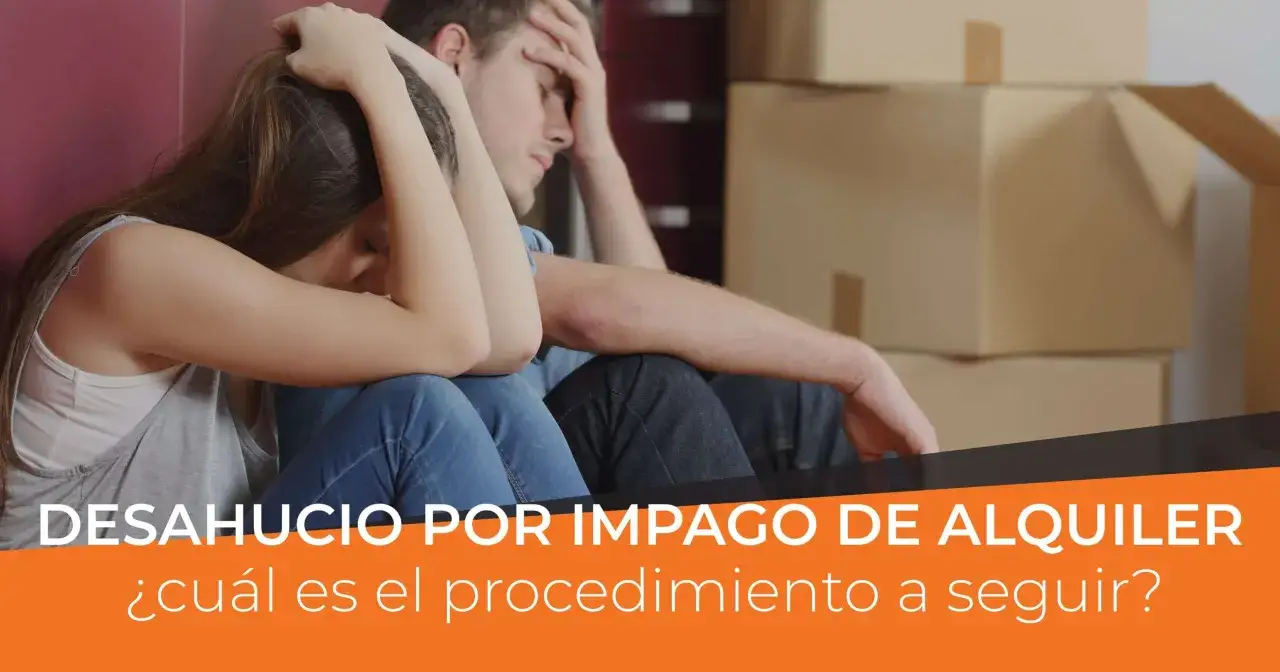 Pareja angustiada sentada entre cajas, preocupada porque me pueden denunciar por no pagar un mes de alquiler.