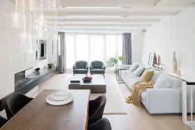 Elegante salón comedor dos ambientes con chimenea, sofás grises, mesa de centro y comedor de madera.