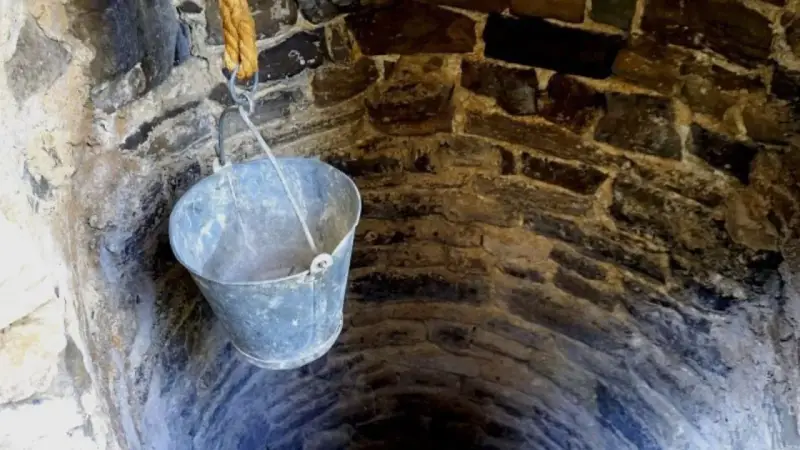 Un cubo cuelga de una cuerda en un pozo de piedra. ¡Qué útil sería si pudiera hacer un pozo en mi parcela!